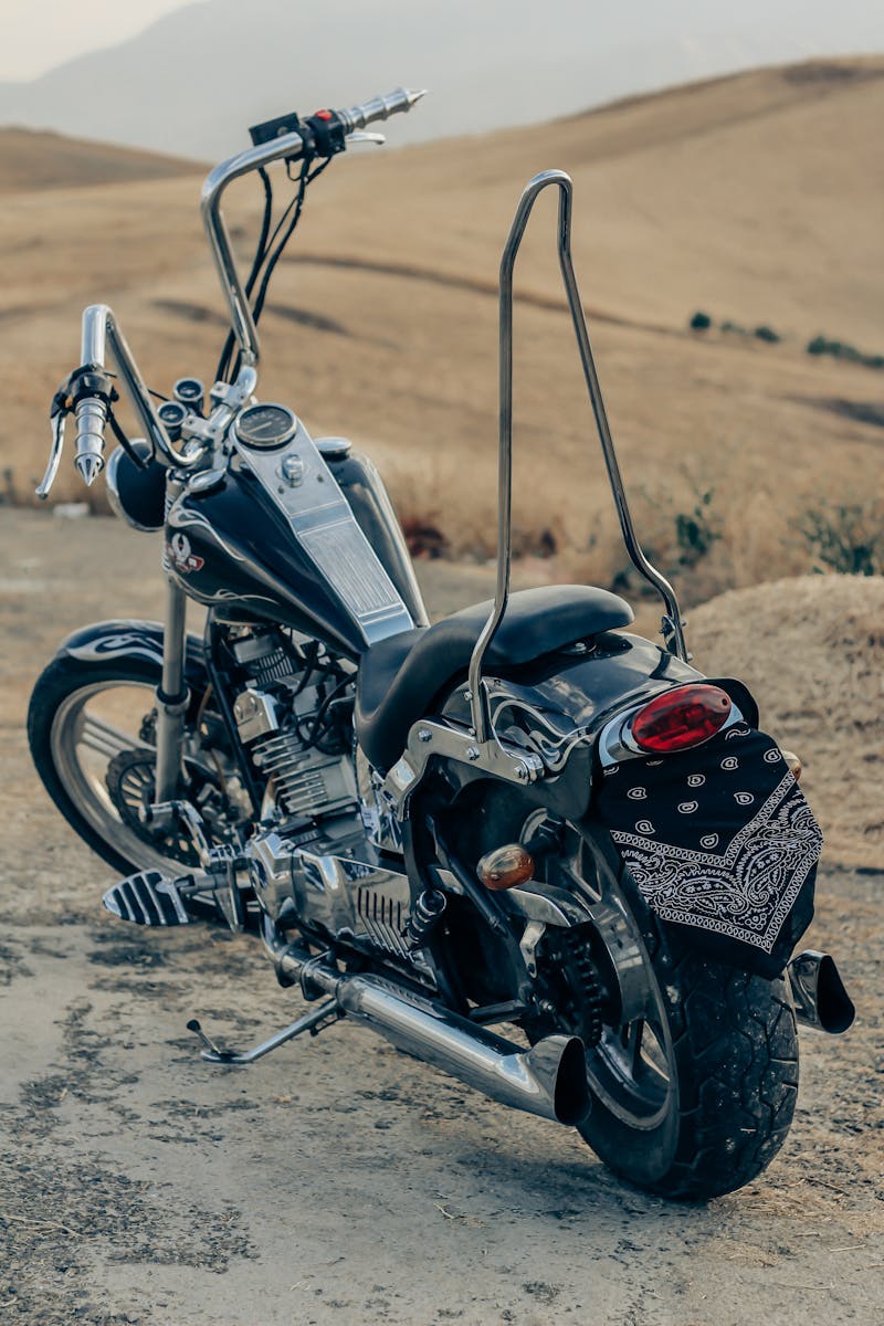 A black motorcycle parked on a dirt road in Urmia, Iran, showcasing vintage design.